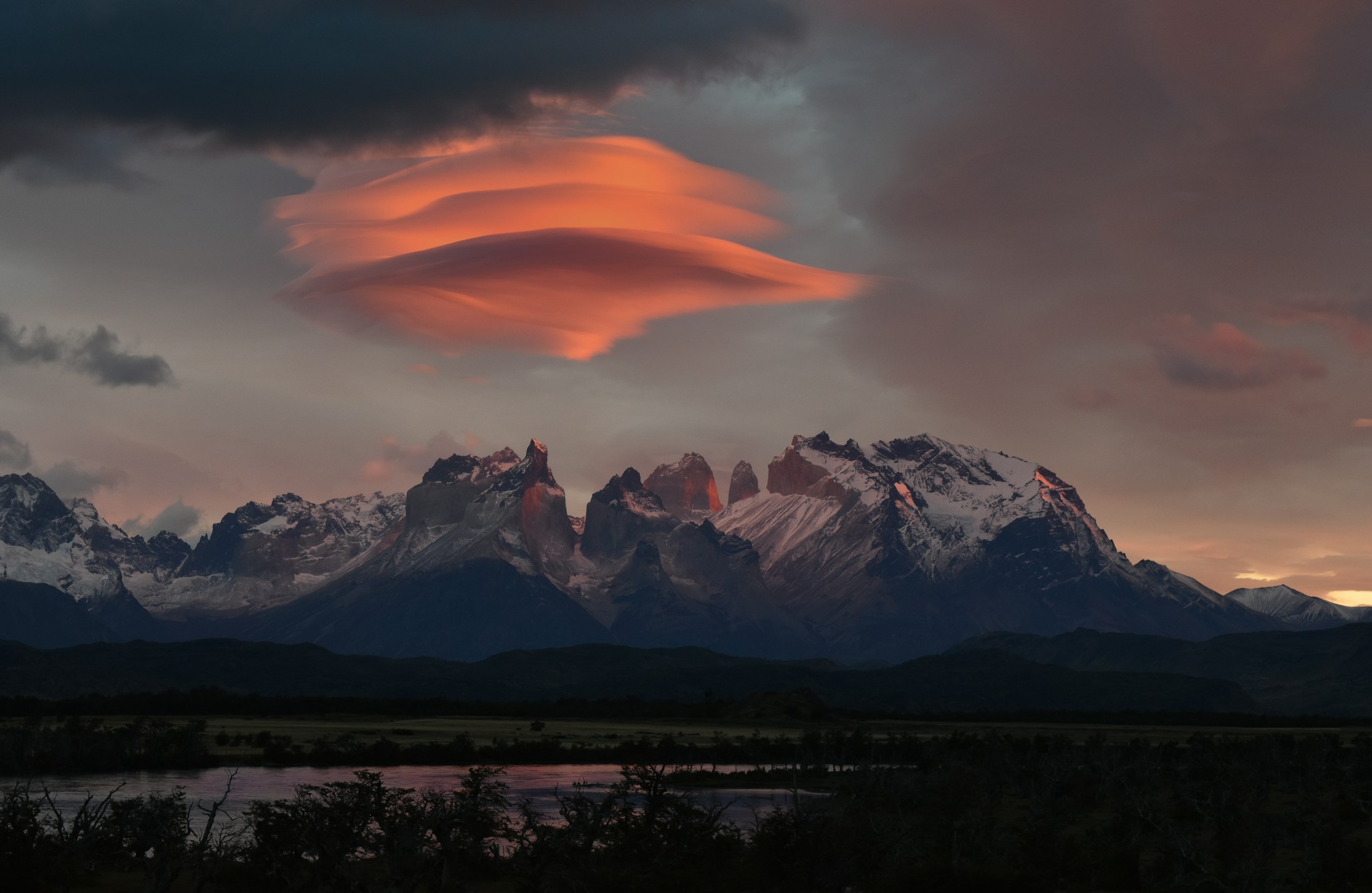 Estepe patagônica ao entardecer, com montanhas nevadas ao horizonte